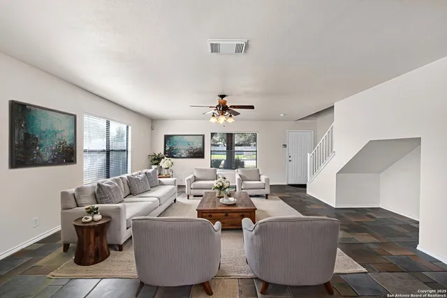 a living room with furniture a chandelier and a window