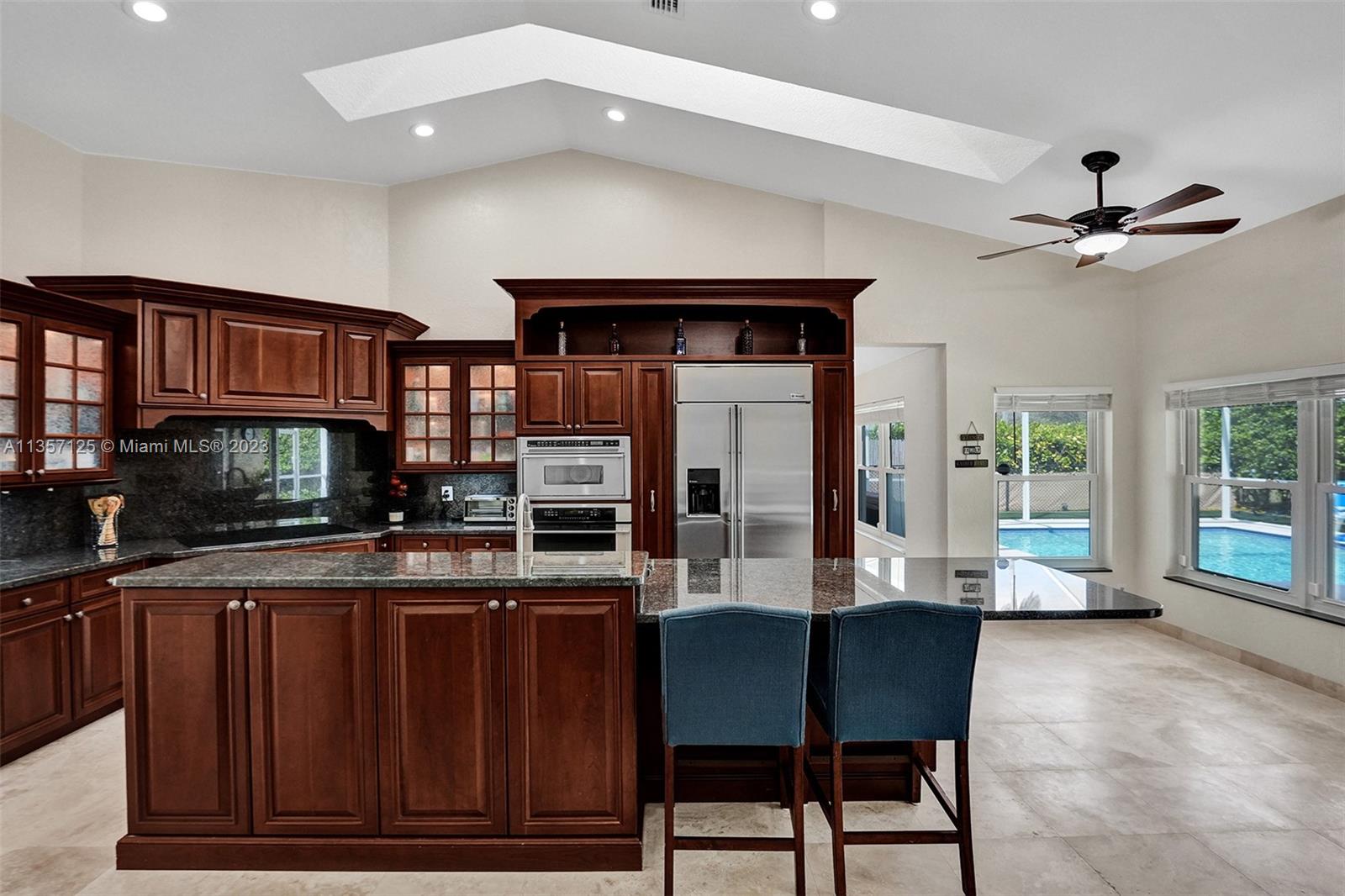 22190 Appleton Drive Boca Raton, FL 33428 - Photo 12 of 41 a living room with stainless steel appliances kitchen island granite countertop a table chairs and a wooden floor