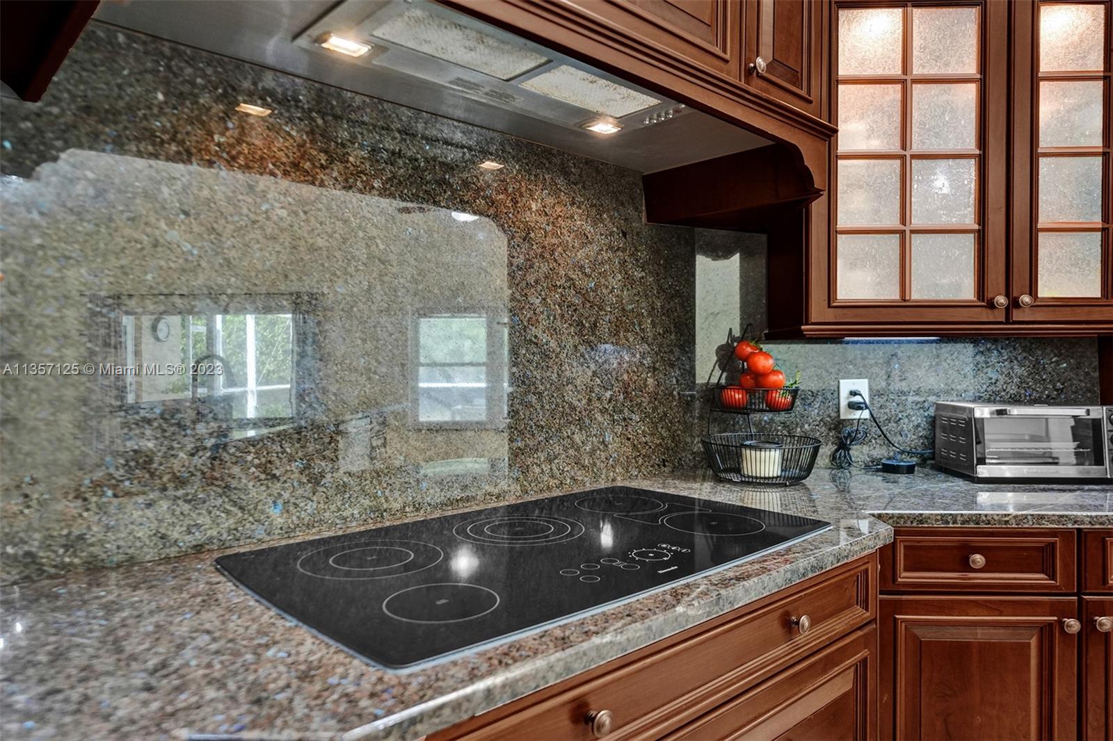 22190 Appleton Drive Boca Raton, FL 33428 - Photo 5 of 41 a kitchen with granite countertop a stove a sink and a microwave