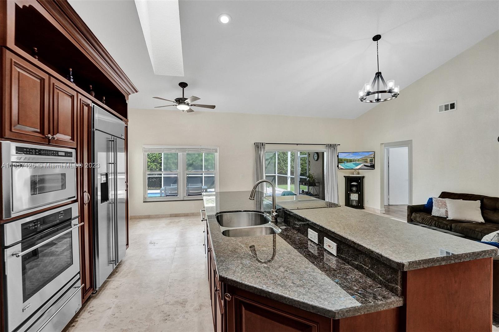 22190 Appleton Drive Boca Raton, FL 33428 - Photo 6 of 41 a kitchen with a stove a sink dishwasher a kitchen island with wooden cabinets and floor