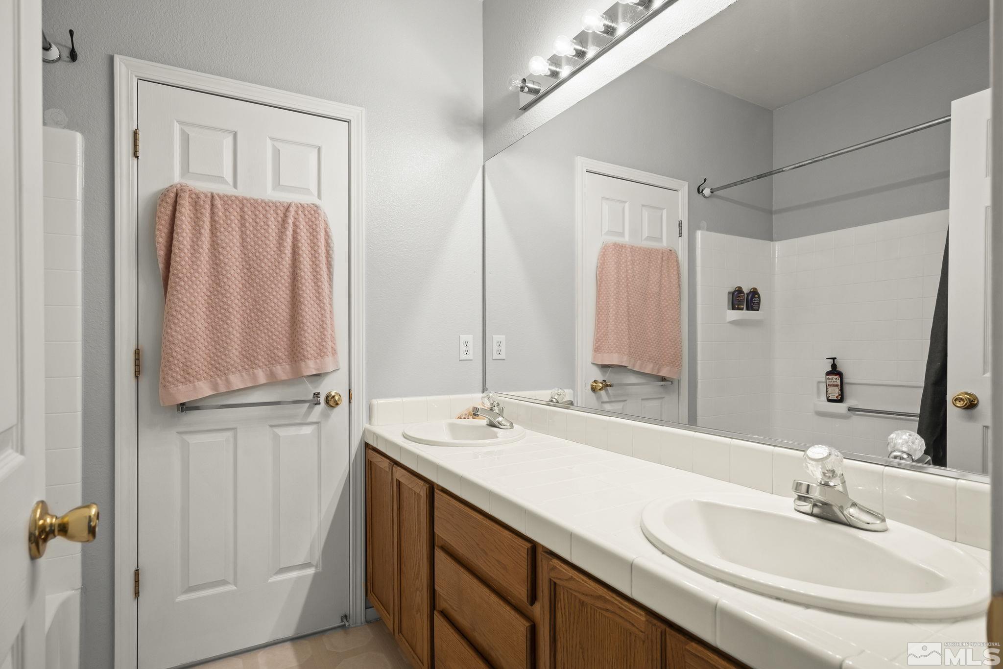 1465 Cayuse Way Reno, NV 89521 - Photo 16 of 26 a bathroom with a double vanity sink and a mirror