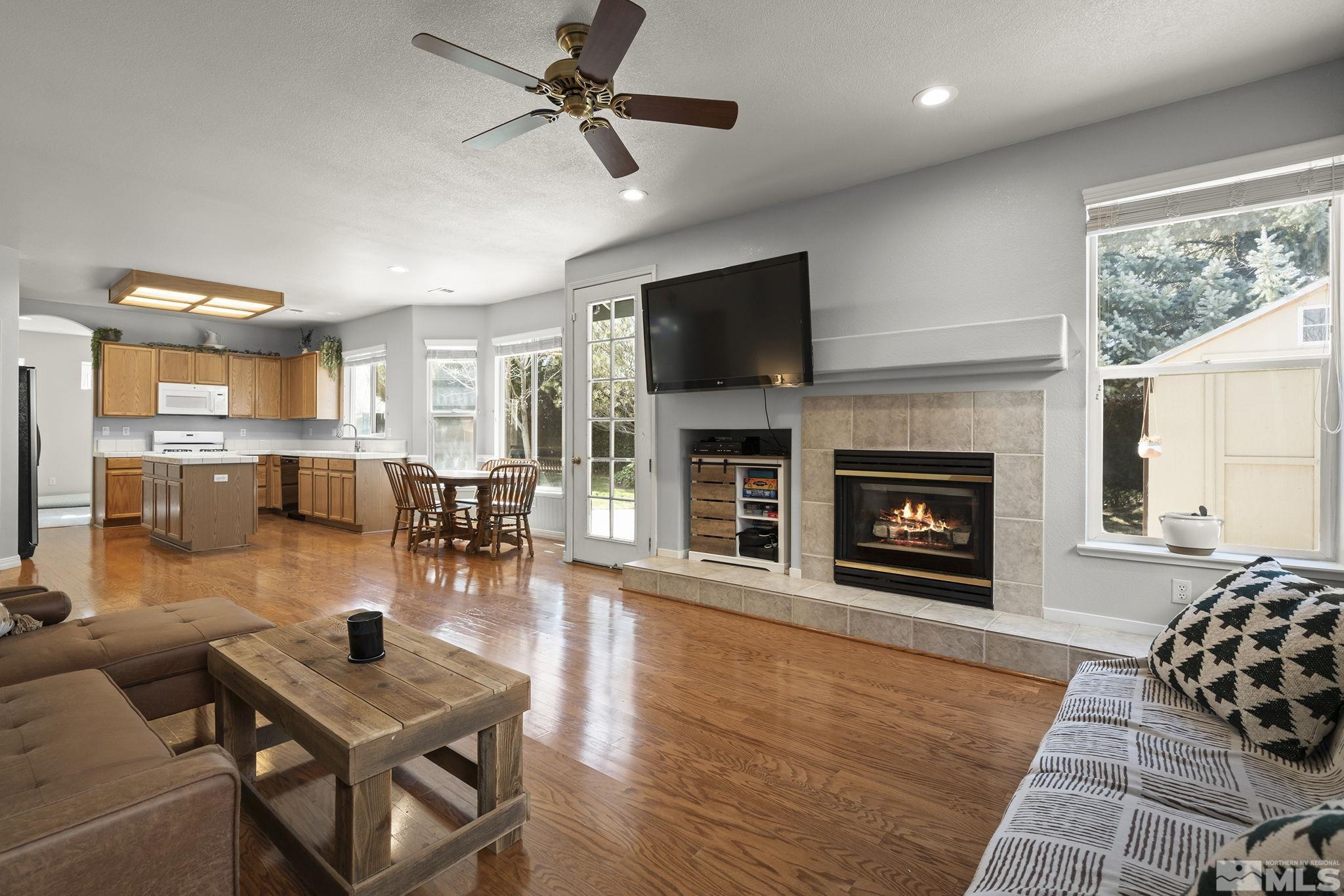 1465 Cayuse Way Reno, NV 89521 - Photo 7 of 26 a living room with furniture a flat screen tv and a fireplace