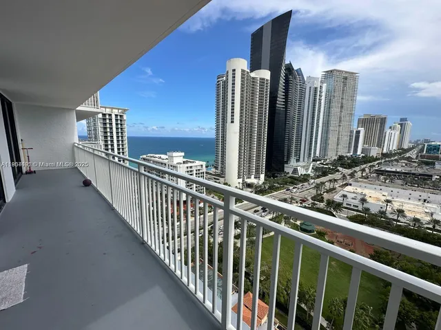 a view of a balcony with two chairs and a large window