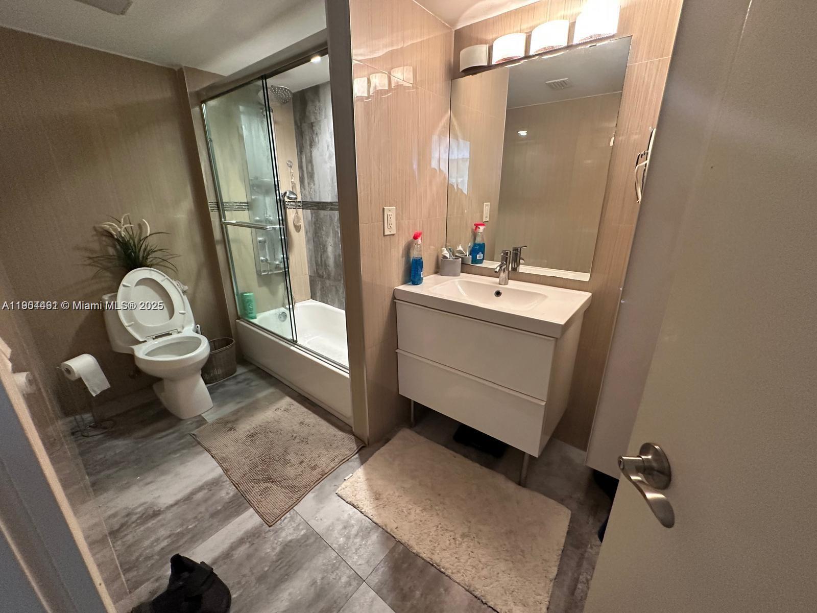 210 174th Street, Unit 2202 Sunny Isles Beach, FL 33160 - Photo 5 of 12 a bathroom with a toilet sink and mirror