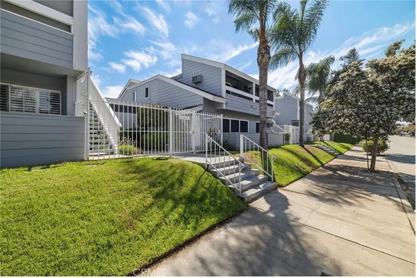 a view of a house with a small yard and wooden fence