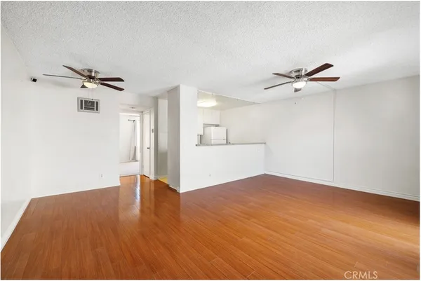 a view of a room with a wooden floor and a ceiling fan