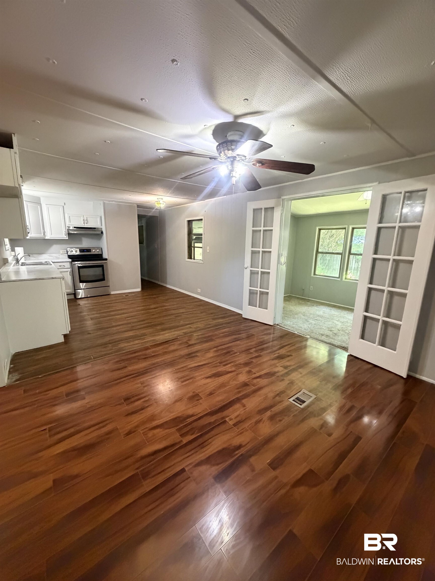 1354 Caney Loop Lillian, AL 36549 - Photo 11 of 45 Expansive living area featuring wood-finish flooring, a ceiling fan with integrated lighting, and recessed ceiling lights