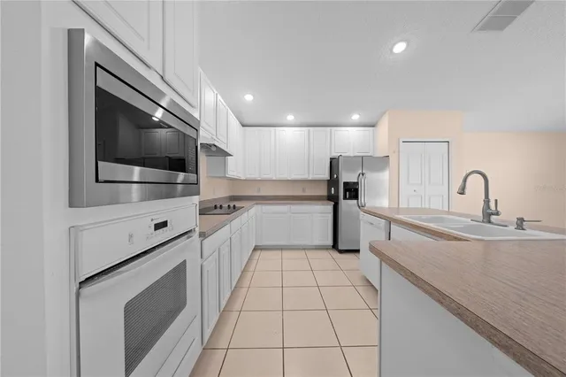 a view of a livingroom with a chandelier fan and windows