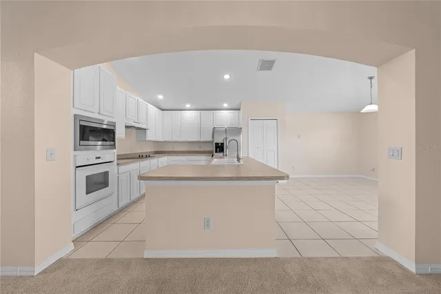 an empty room with windows and ceiling fan