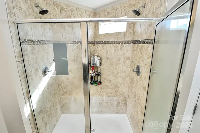 a bathroom with a glass shower door and a glass door shower