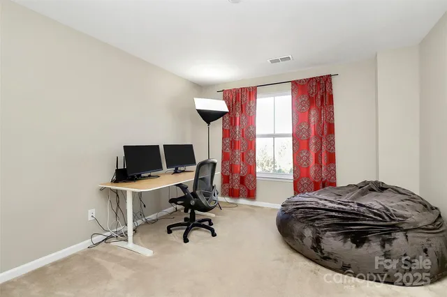 a view of a workspace with furniture and a window