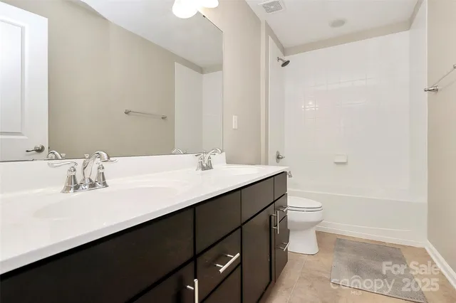 a bathroom with a double vanity sink toilet and shower