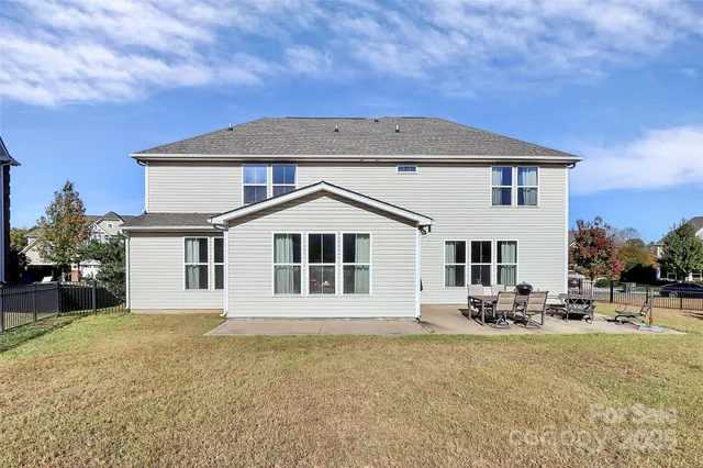 a front view of a house with large trees