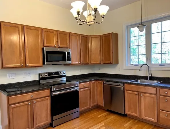 a kitchen with stainless steel appliances granite countertop a sink dishwasher a stove microwave and cabinets