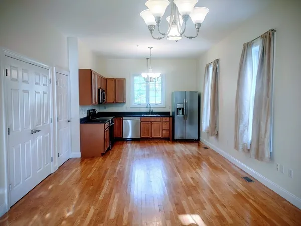 a view of a kitchen with a sink and dishwasher a refrigerator with wooden floor