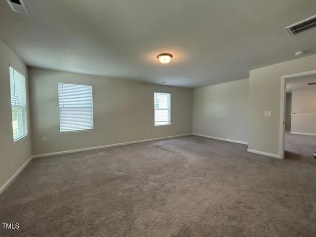 an empty room with windows and entrance to other room