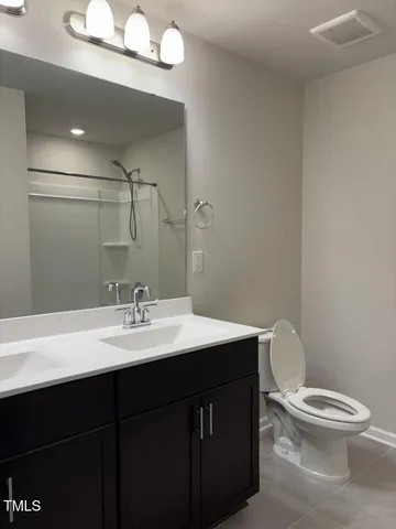 a bathroom with a sink a toilet a mirror a vanity and bathtub