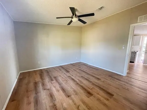 a view of empty room with wooden floor