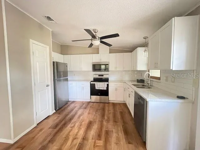 a kitchen with granite countertop a refrigerator oven a sink dishwasher and a stove top oven