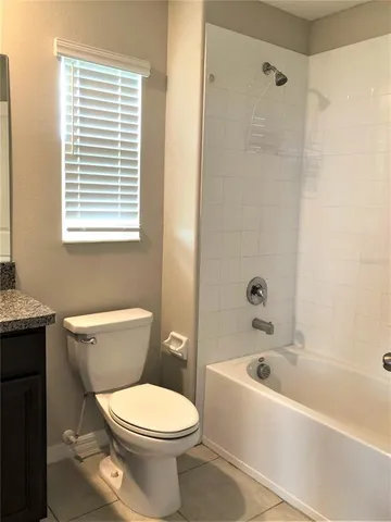 a white toilet sitting next to a bath tub and shower