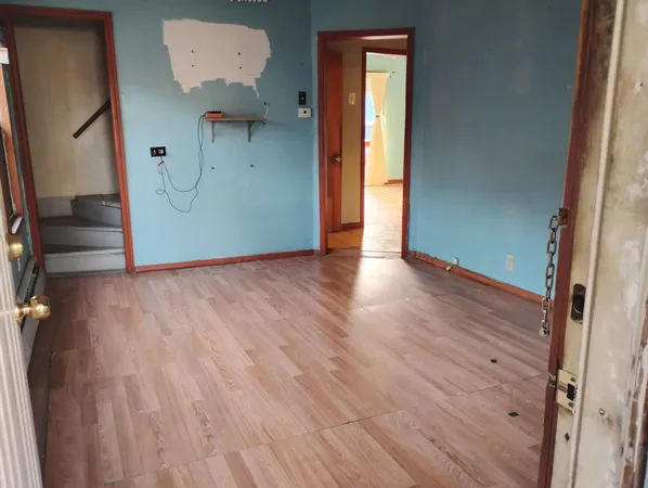 an empty room with wooden floor and a entrance