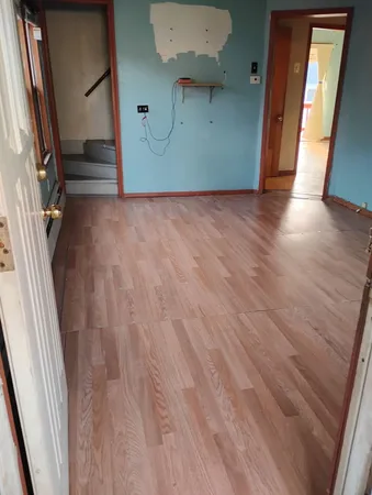 a view of a hallway with wooden floor and staircase
