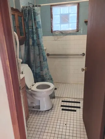 a bathroom with a toilet and a shower
