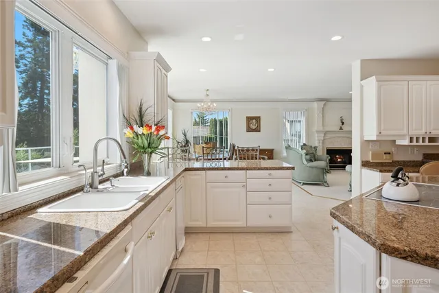 a kitchen with granite countertop a sink stove and cabinets