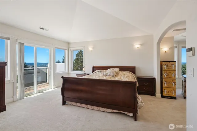 a spacious bedroom with a bed and a dresser