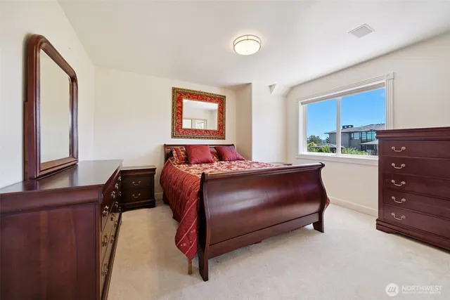 a bedroom with a bed and a dresser next to a window