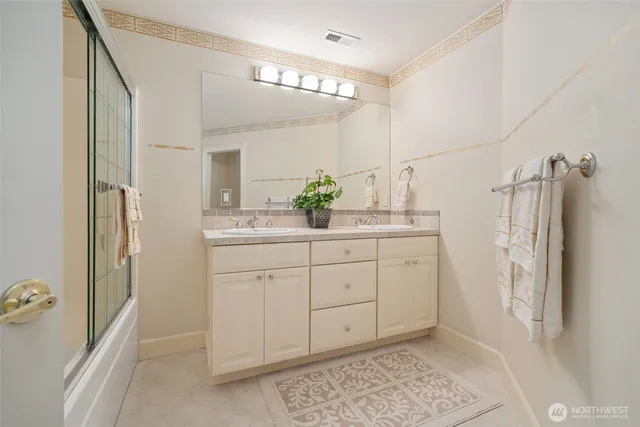 a bathroom with a double vanity sink and a mirror