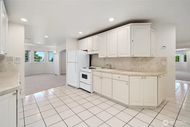 a kitchen with white cabinets a sink stove and white cabinets