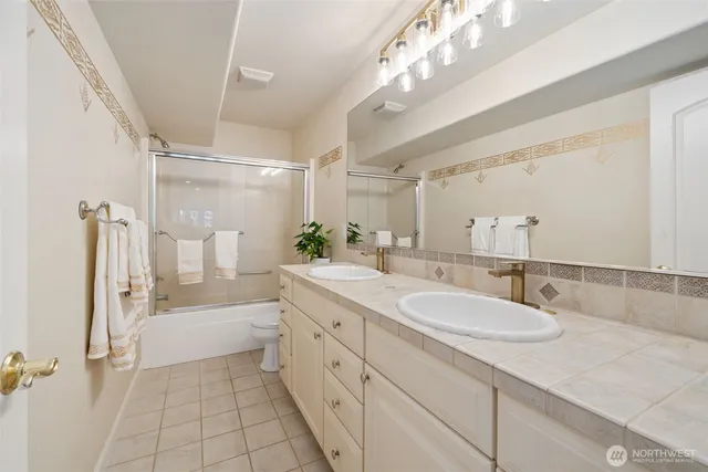a bathroom with a sink a large mirror and shower