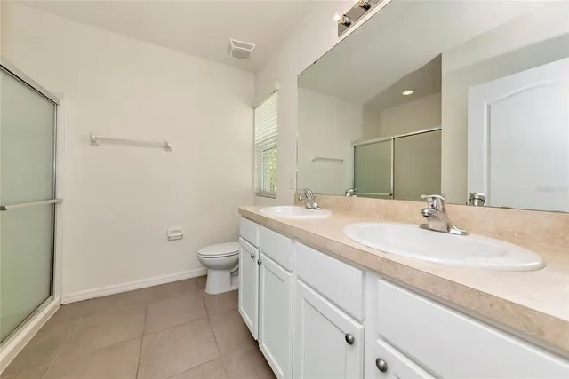 a bathroom with a double vanity sink toilet and mirror