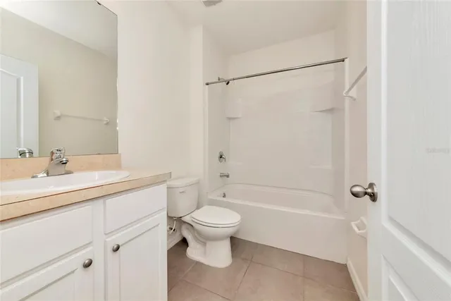 a bathroom with a granite countertop sink a toilet and shower