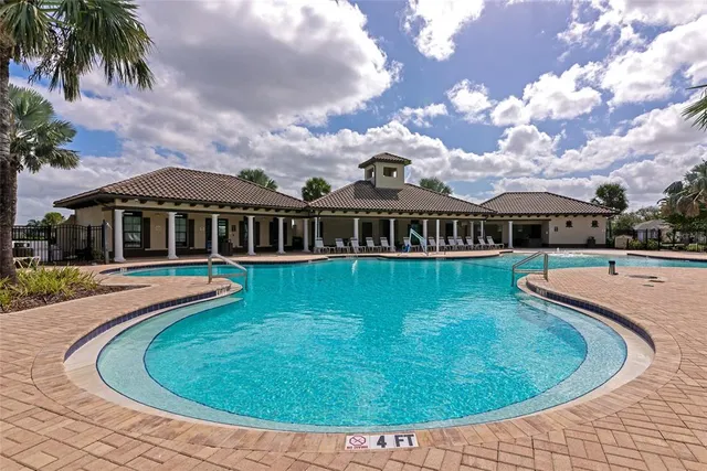 a view of a house with swimming pool and sitting area