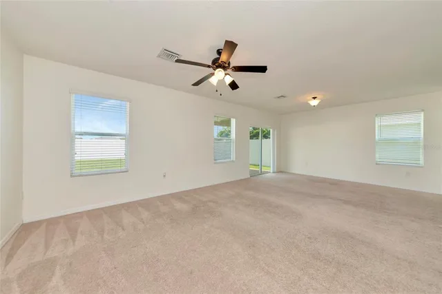 a view of a livingroom with a ceiling fan and window