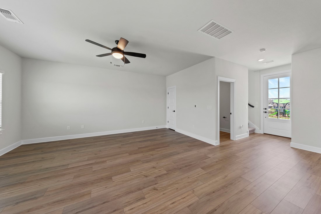 9509 Demure Drive, Unit 4 Manor, TX 78653 - Photo 6 of 21 an empty room with wooden floor ceiling fan and windows