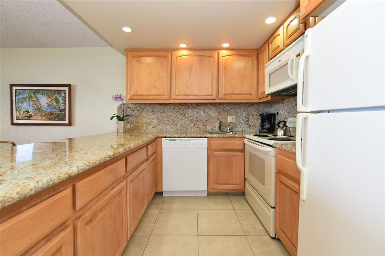 3543 Lower Honoapiilani Road, Unit L302 Lahaina, HI 96761 - Photo 23 of 28 a kitchen with granite countertop a sink a counter top space stainless steel appliances and cabinets