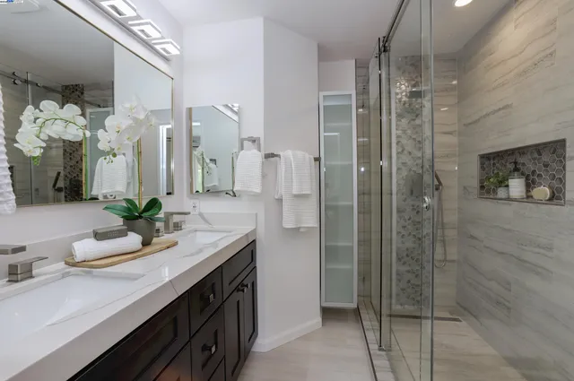 a bathroom with a double vanity sink mirror and shower