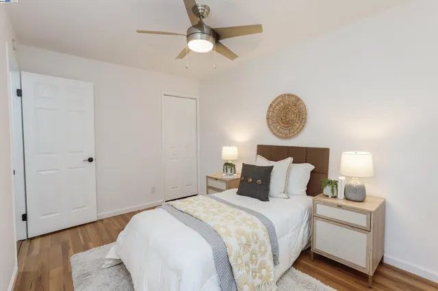 a bedroom with a bed and a lamp on dresser