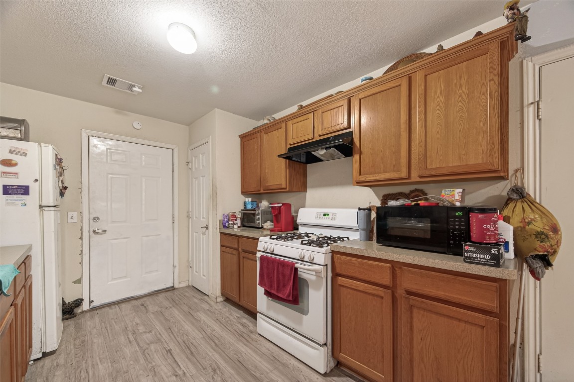 7100 Harlem Street Baytown, TX 77521 - Photo 15 of 30 a kitchen with a sink a stove and cabinets
