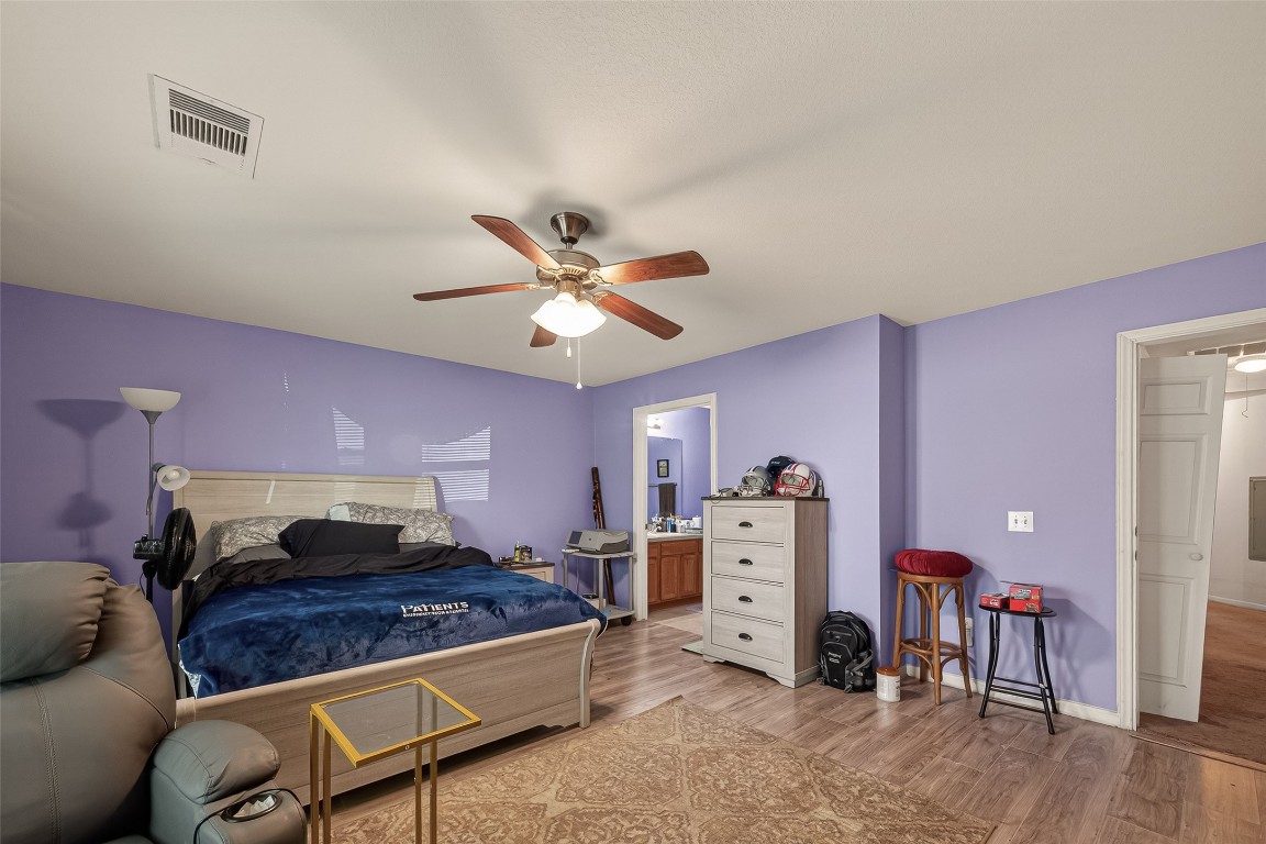 7100 Harlem Street Baytown, TX 77521 - Photo 23 of 30 a bed room with furniture and a chandelier