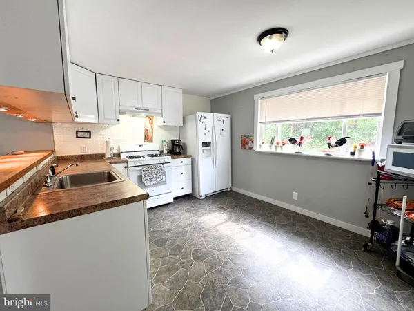 a kitchen that has a lot of cabinets a sink and a stove