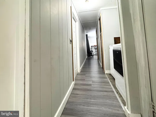 a hallway with wooden floor and staircase