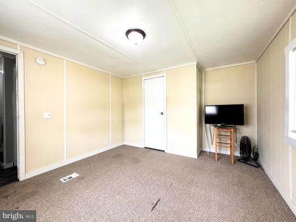 a living room with flat screen tv and a refrigerator