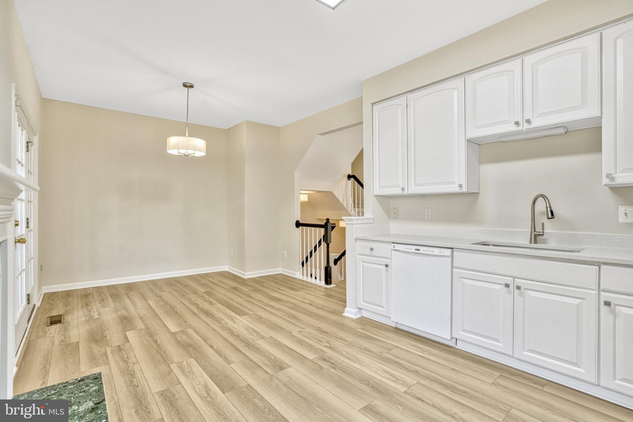 10159 Elgin Way Bristow, VA 20136 - Photo 27 of 50 a kitchen with granite countertop a sink cabinets and wooden floor
