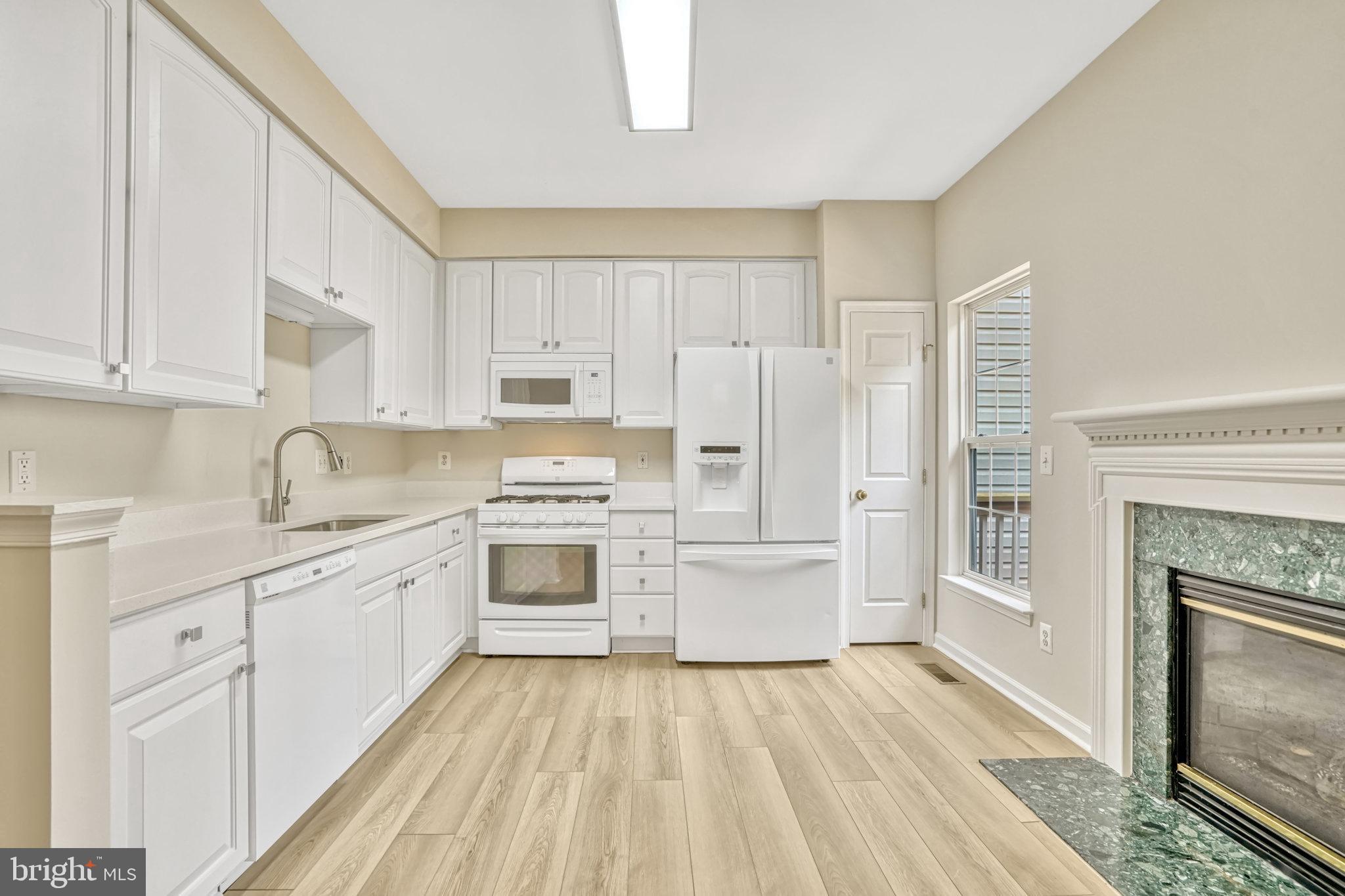 10159 Elgin Way Bristow, VA 20136 - Photo 28 of 50 a kitchen with white cabinets and white appliances