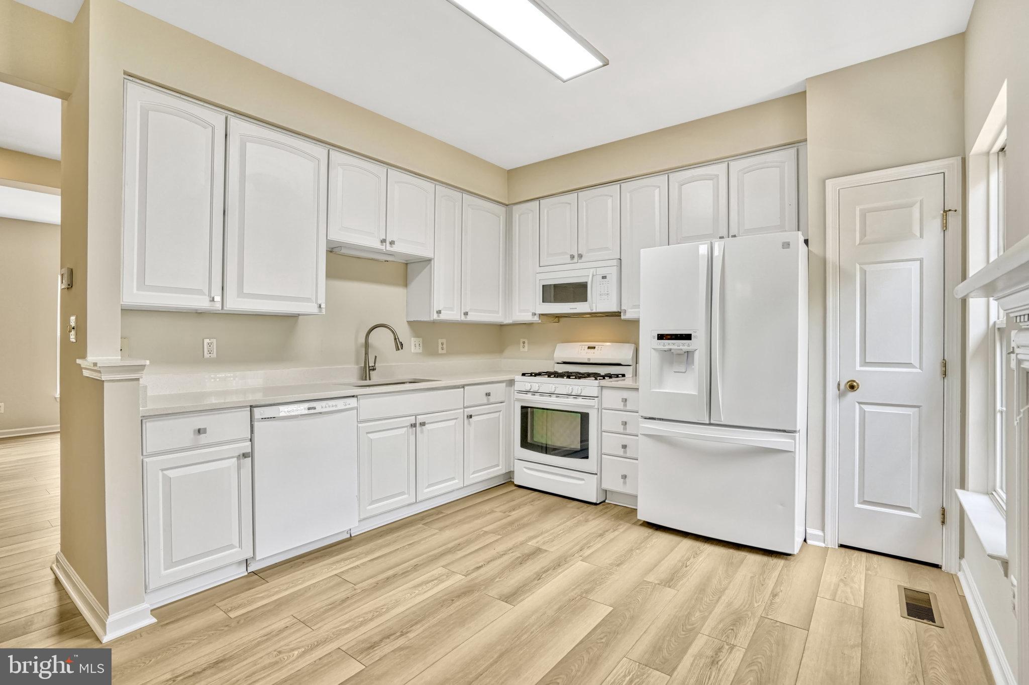 10159 Elgin Way Bristow, VA 20136 - Photo 29 of 50 a kitchen with white cabinets and white appliances