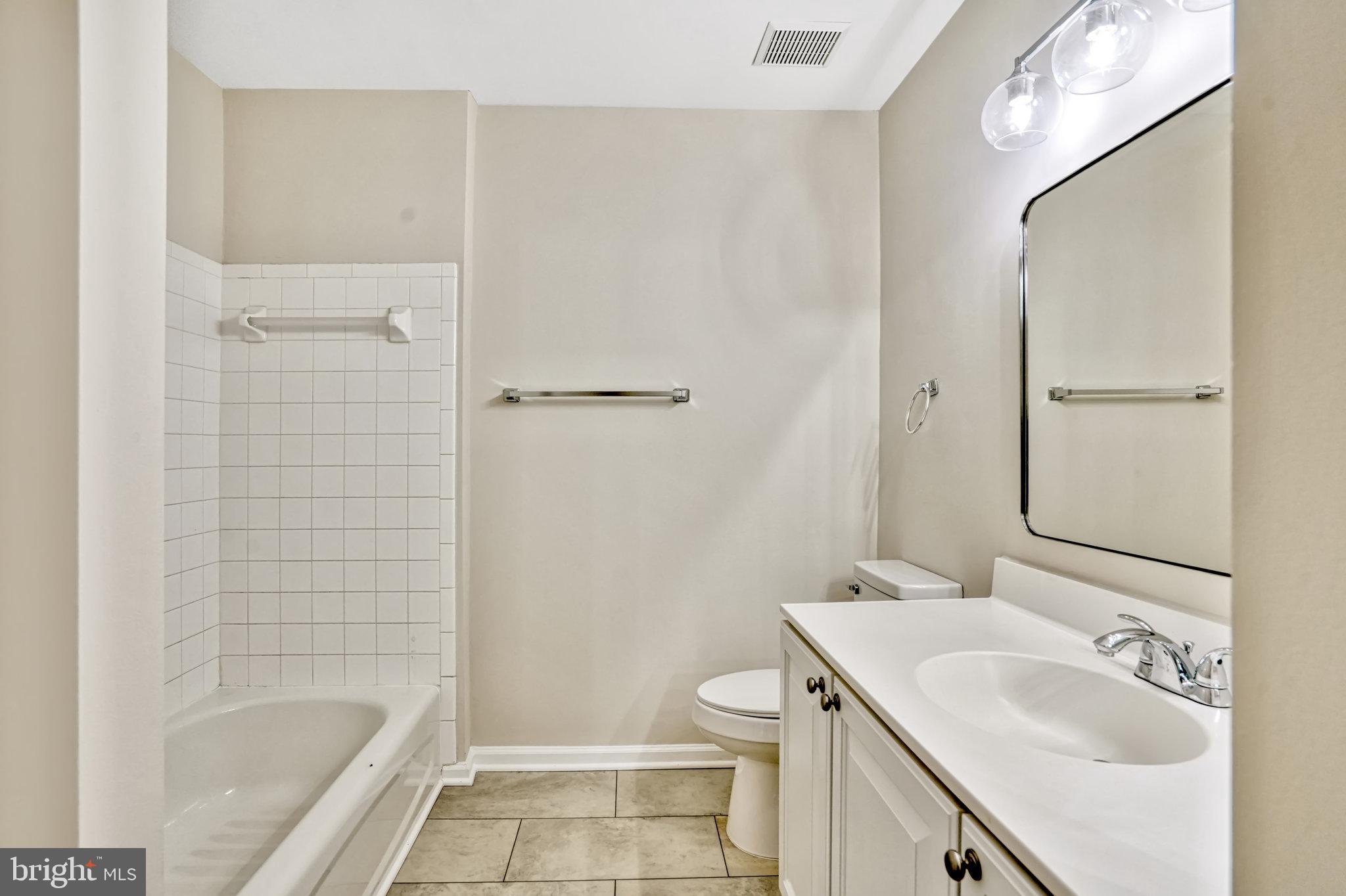 10159 Elgin Way Bristow, VA 20136 - Photo 32 of 50 a bathroom with a granite countertop sink a toilet and shower